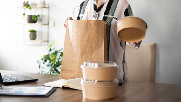 adult woman taking food order out of cardboard package