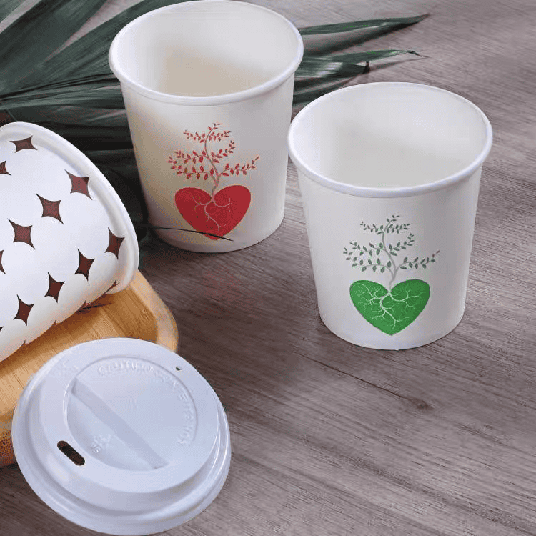 white paper cups with red heart printing and a lid aside